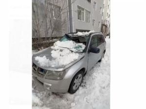 В Якутске упавший снег смял крышу припаркованной машины